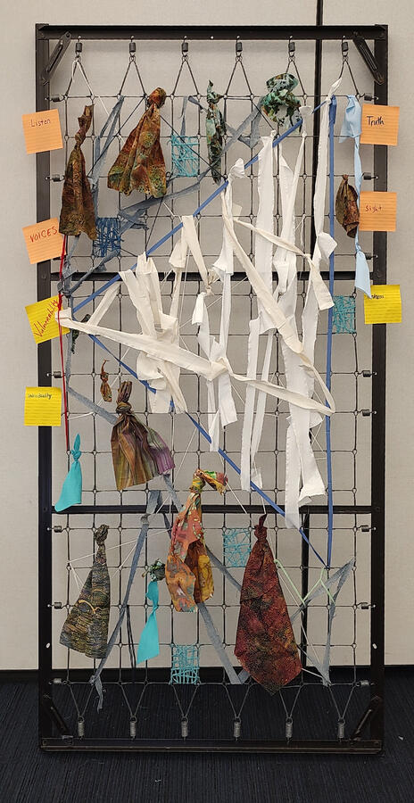 Shark tooth Shark tooth - a bed frame with colorful yarn wrapped around the wire except for an area with white bandages made to look like a shark tooth.